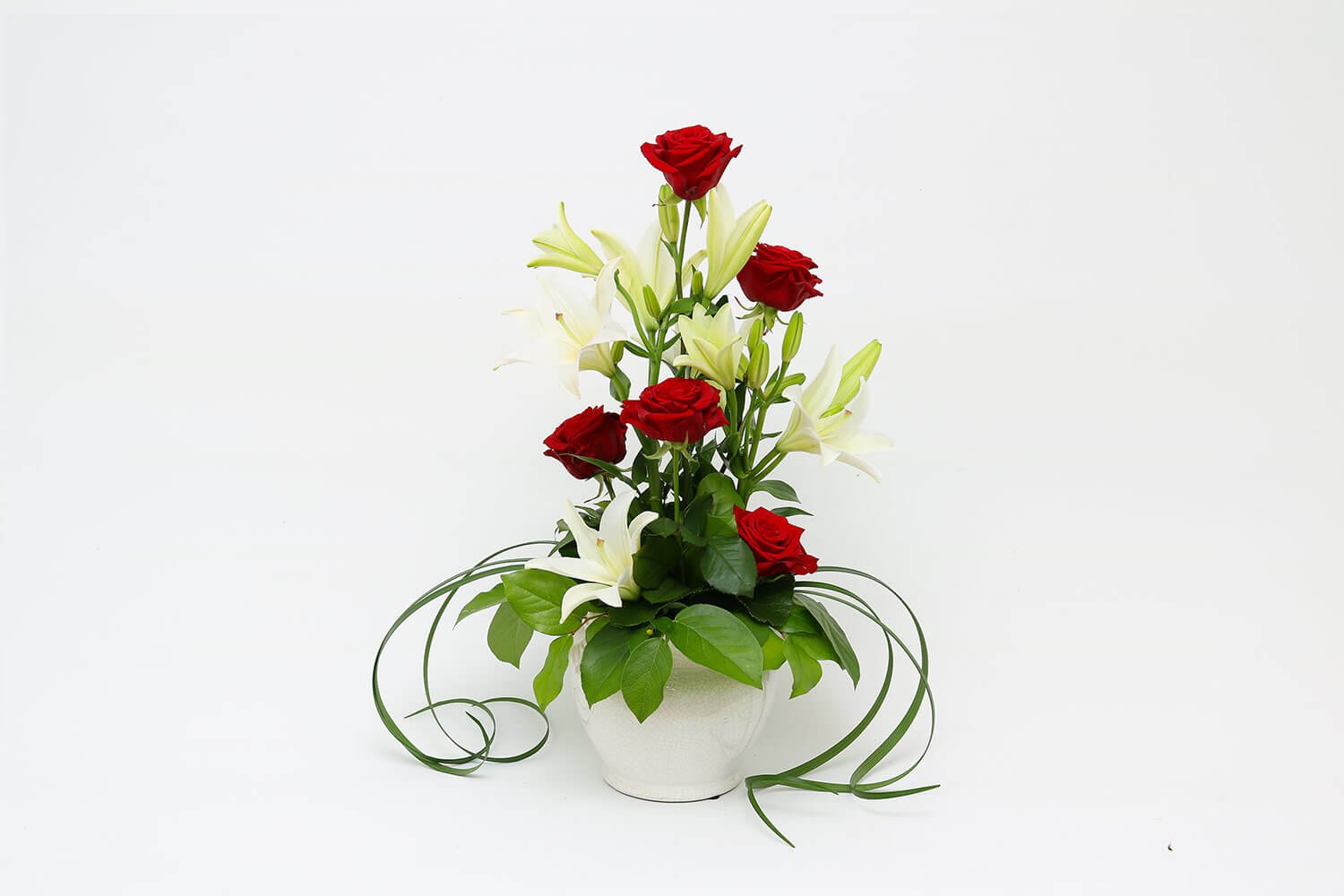 Klassinen kukka-asetelma ruusuista ja liljoista
